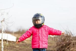 portrait of a little girl smiling in a protective helmet female child in motocross moto helmet. biker girl in motocross helmet photo