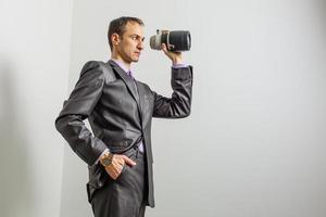 hombre de negocios tomando sosteniendo una lente sobre fondo blanco foto