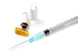 3 ml. brown ampules and glass of drug has already opened and plastic syringe in a medical needle on white background. photo