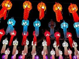 vista colorida de linternas de estilo lanna tailandés para colgar frente al templo en la noche en el festival de loy kratong. foto