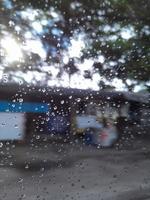 gotas de lluvia en el parabrisas con fondo colorido foto
