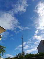 torre transmisora con un fondo de cielo azul y nubes foto