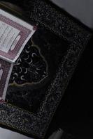 Al-Quran which is above the prayer rug with a black background photo