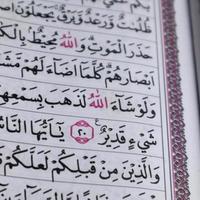 closeup on the verses of the Quran or Koran. focus on the red lafadz allah text photo