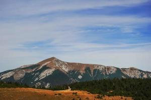 view to a high mountain with a house on the summit photo