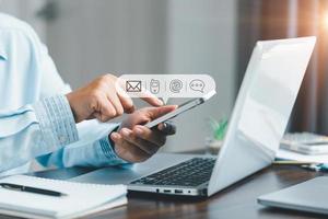 Businesswoman using phone and touching on virtual screen contact icons such as email, address, live chat, internet wifi. Contact us or Customer support hotline people connect. Connect with cyberspace. photo