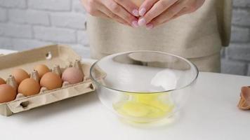 Woman hands breaking an egg, preparing to make dough, making pie video