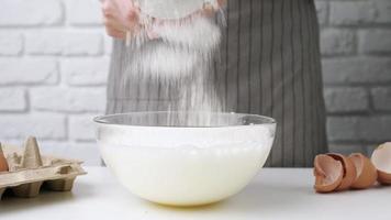 manos de mujer rompiendo un huevo, preparándose para hacer masa, haciendo pastel video