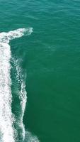 imagens aéreas da praia de areia britânica e oceano. filmagem 4k vertical e estilo retrato da praia de bournemouth com a câmera do drone durante o pôr do sol video