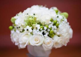Wedding bridal bouquet of white roses on a red background photo