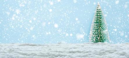 Empty white snow with blur Christmas tree background photo