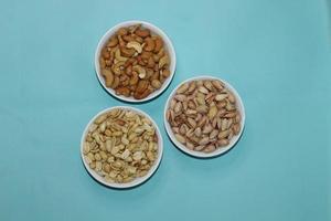 Different dried fruits and nuts on white background, top view. Space for text photo
