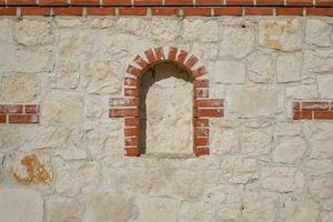 Wild limestone wall decorated with niche bricks, idea for background or interior decoration