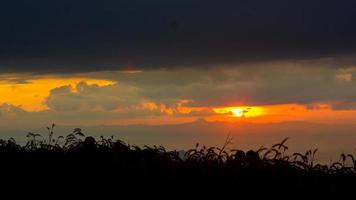 Sunrise in the landscape of hills and meadows. People go up the mountains to see the scenery, the sun, the dawn, and the horizon above the ground photo