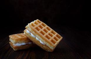 gofres vieneses con crema yacen sobre una mesa de madera. foto