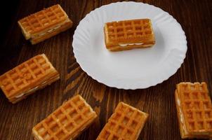 Viennese waffles lie on and next to a white plate. photo