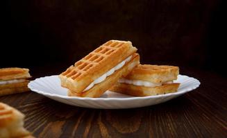 Viennese waffles lie on and next to a white plate. photo