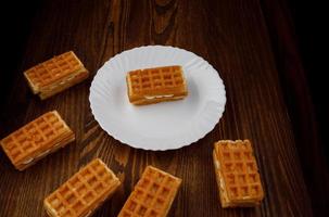 Viennese waffles lie on and next to a white plate. photo