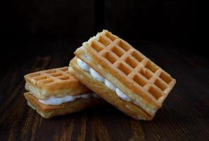 Viennese waffles with cream lie on a wooden table. photo