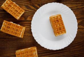 Viennese waffles lie on and next to a white plate. photo