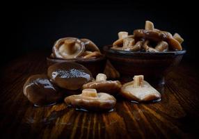 Delicious salted mushrooms on a wooden table . Rustic food . Black milk mushrooms on a wooden table . photo