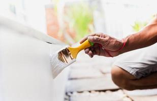 Hand painting outside wall with white color. photo