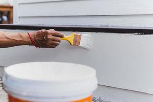 Hand painting outside wall with white color. photo