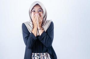 Beautiful young Asian woman making a shocking gesture with closed nice smile isolated over grey background photo