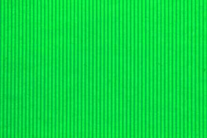 Abstract paper green geometric symmetrical texture striped surface vertical lines background. Structure design cardboard shape backdrop. Holiday spring decoration interior concept. Flatlay, close-up photo