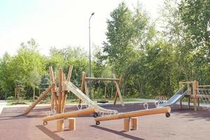 Wooden modern ecological safety children outdoor playground equipment in public park. Nature architecture construction playhouse in city. Children rest and childhood concept. Idea for games on air. photo