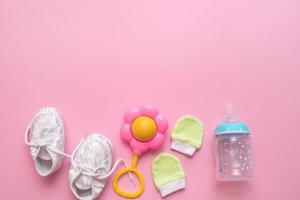 accessories for a newborn on a pink background with copy space photo