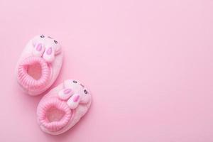 booties in the shape of a hare on a pink background with copy space photo