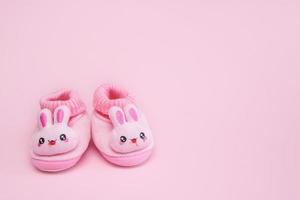 booties in the form of hares on a pink background with copy space photo