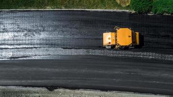 Aerial view on the new asphalt road under construction photo