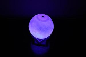 Complex moon lamp that has different colors concepts.This lamp also has a brown support that makes it stand still photo