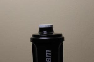 The top of a shaker that has a white cap and the colour of the container is black photo