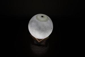 Complex moon lamp that has different colors concepts.This lamp also has a brown support that makes it stand still photo