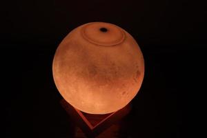 Complex moon lamp that has different colors concepts.This lamp also has a brown support that makes it stand still photo