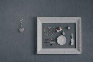 Home wall decoration showing a frame, vintage tableware with flower details and heart shaped ornaments photo