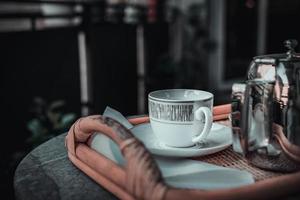 una taza de café y una cafetera en una bandeja en un balcón foto