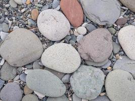 Big stones on the beach. Background from stones. Boulders on the seashore. Smooth cobblestones. photo