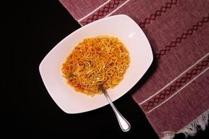 Instant like maruchan soup in white plate on black background photo