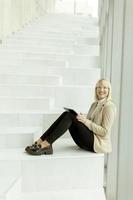 Businesswoman with digital tablet on modern office stairs photo