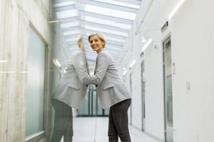 Businesswoman standing on modern office hallway photo