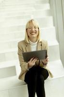 mujer de negocios con tableta digital en las escaleras de la oficina moderna foto