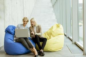 Businesswomen using laptop computer on lazy bags in the modern office photo