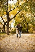 Young couple walking in the autumn park photo