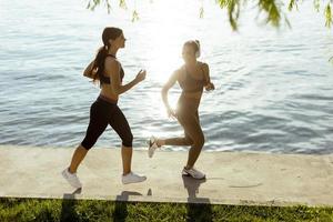 Mujer joven haciendo ejercicio para correr por el paseo fluvial foto