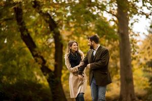 Young couple walking in the autumn park photo