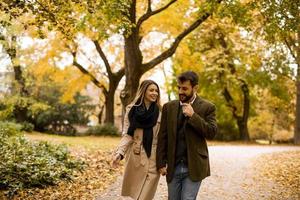 Young couple walking in the autumn park photo